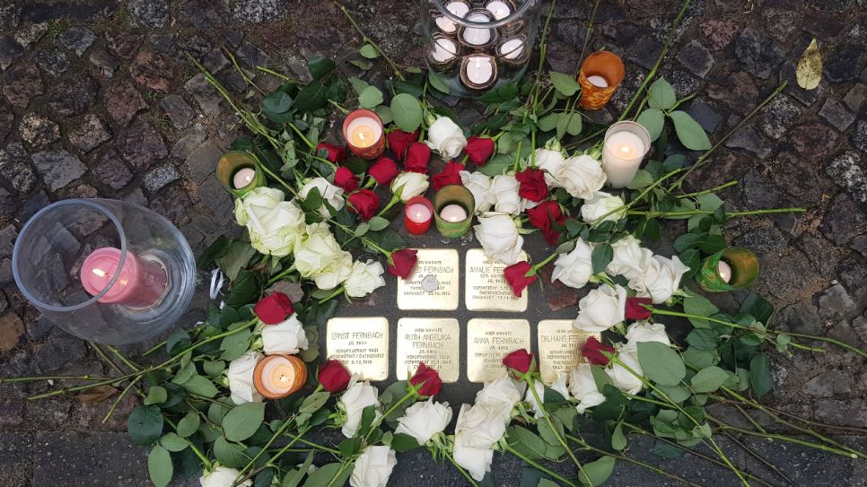 Fünf Messingquadrate im Boden, darum Blumen